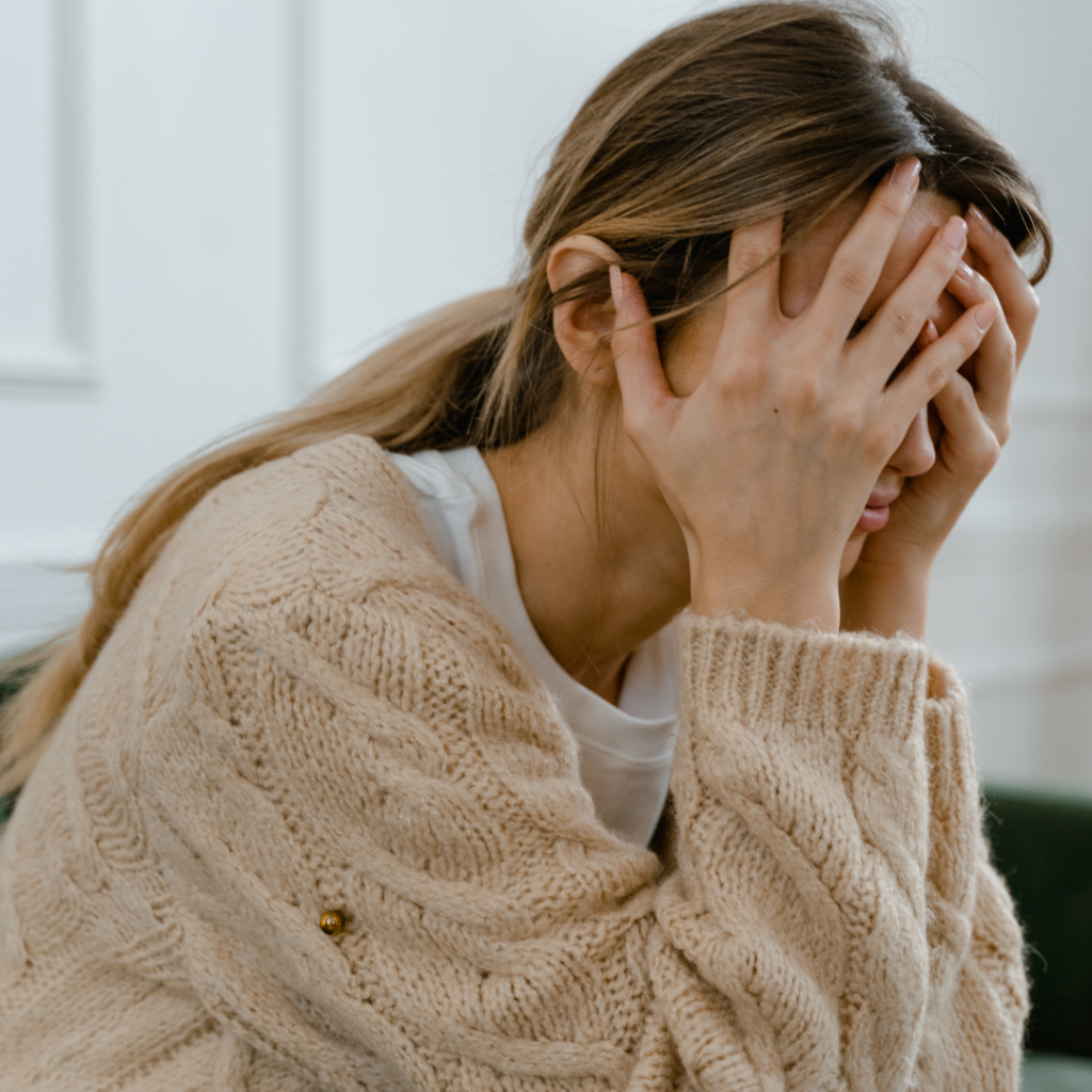 Woman Sitting with Hands Covering Her Face