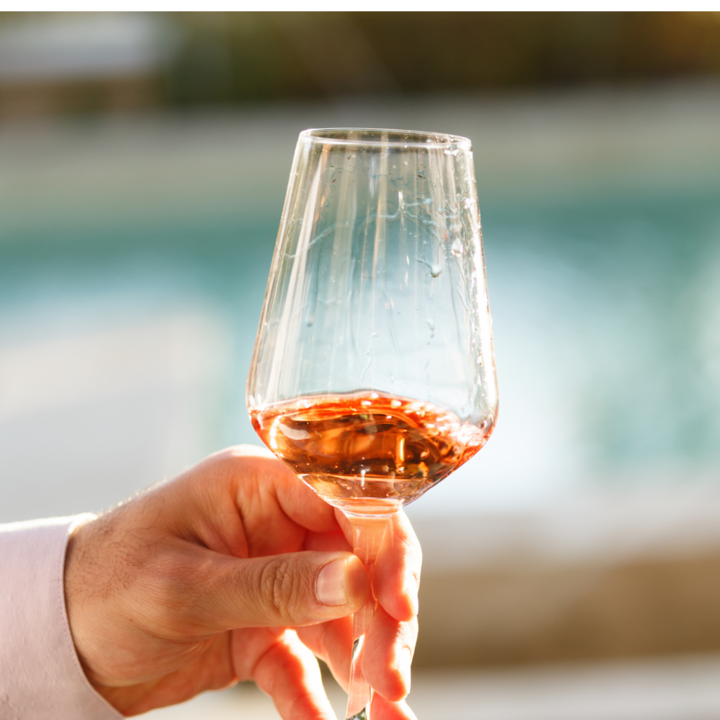 Swirling glass of rose wine at wine tasting. Concept of rose wine