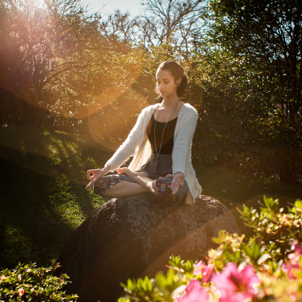 Woman Meditating on Rock