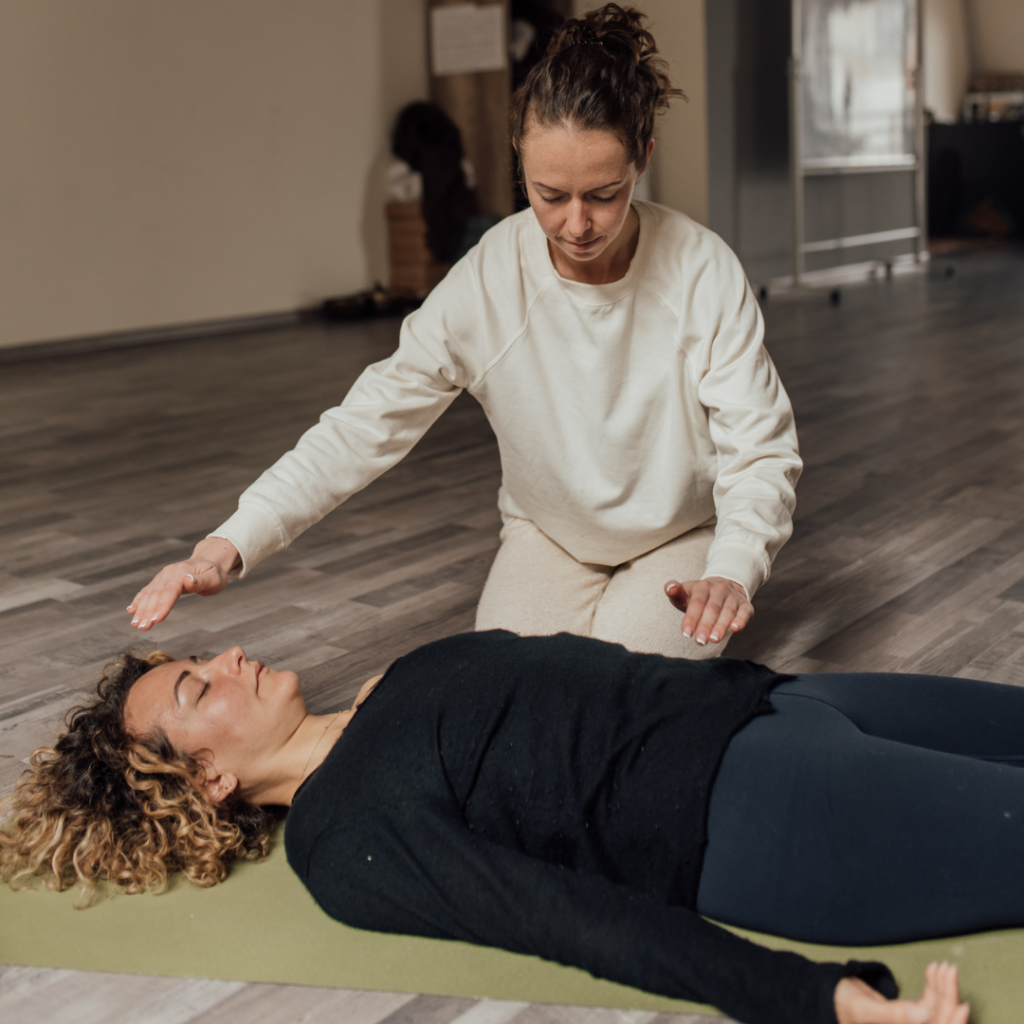 Woman in Black Long Sleeve Shirt Lying Down beside Woman Kneeling on the Floor