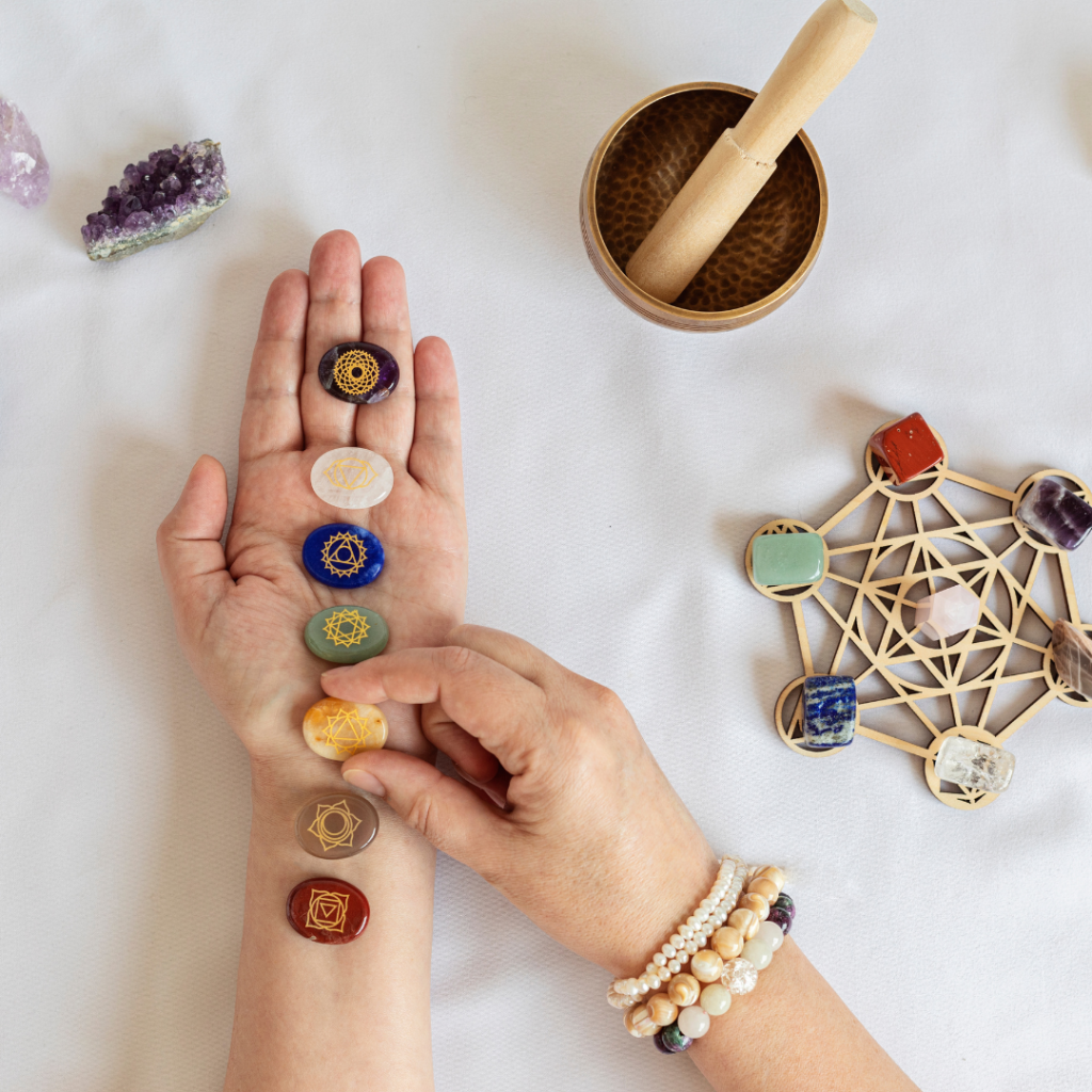 Healing reiki chakra crystals on woman's hands. Gemstones for wellbeing, meditation, relaxation