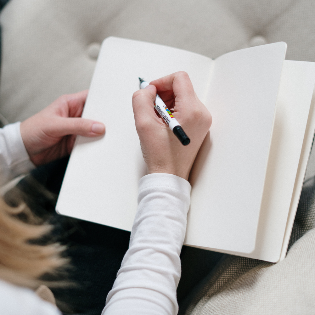 Person Writing On A Notebook