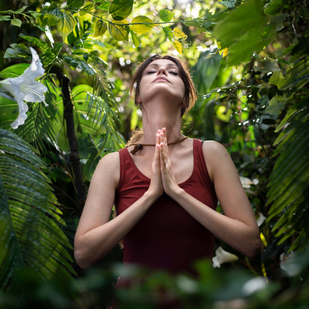 Woman practicing breathing yoga pranayama in rainforest