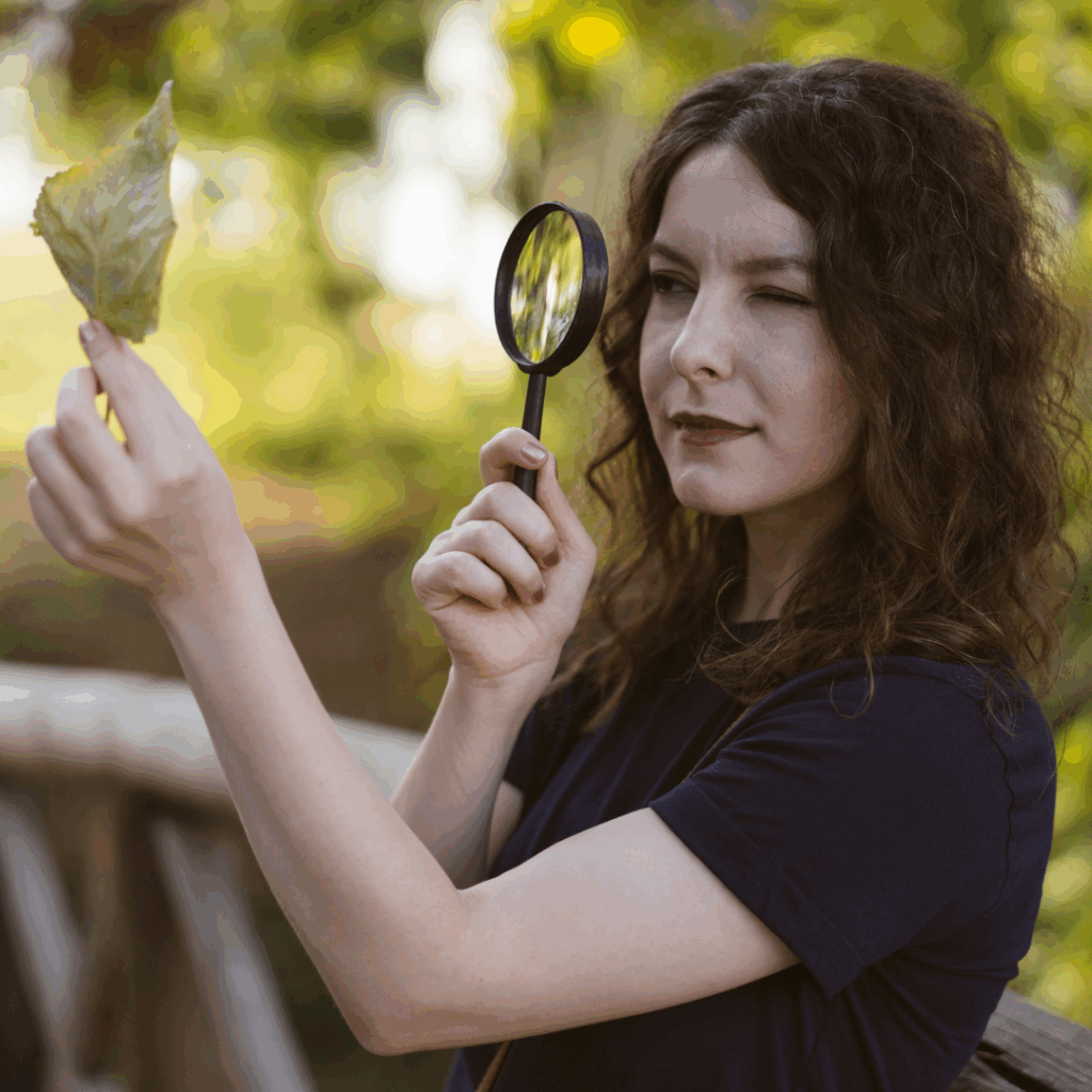 Woman using magnifying glass outdoors