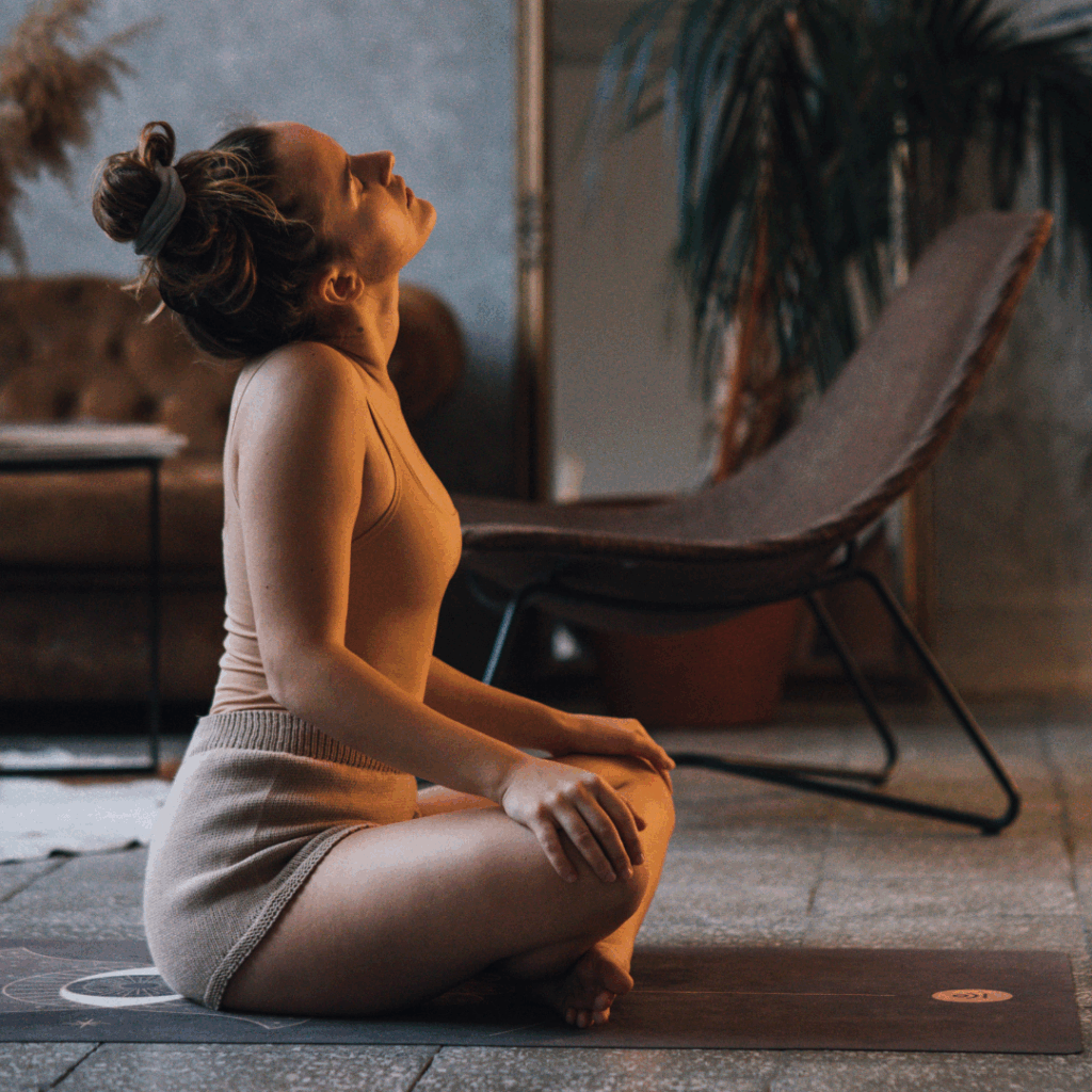 Photo of a Woman Stretching Her Neck Near Her Laptop