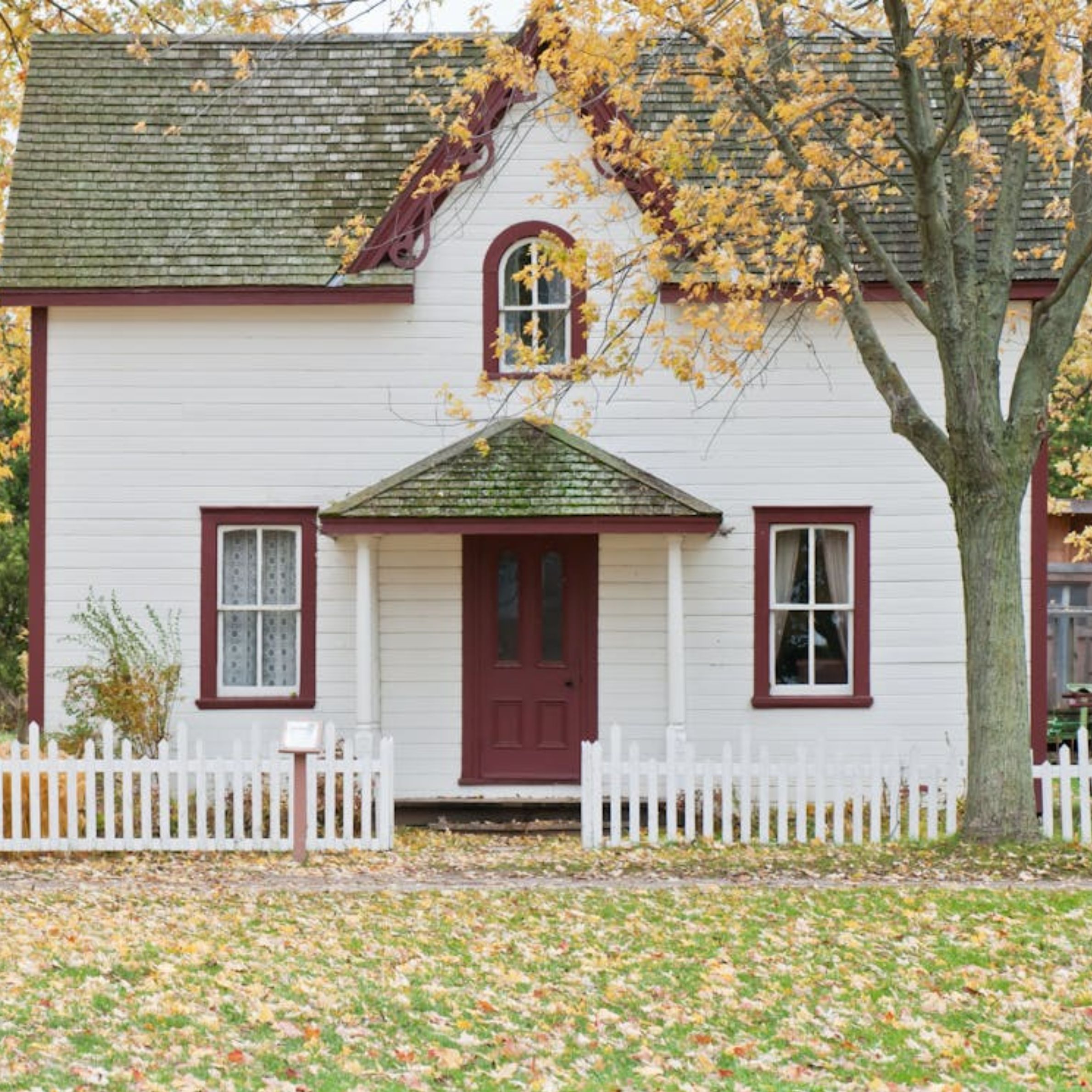 White and Red Wooden House With Fence